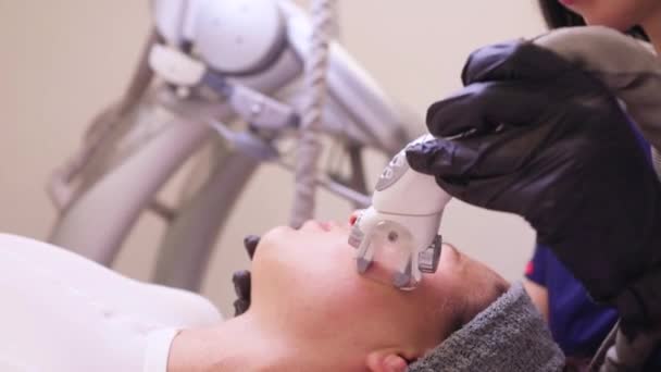 Proces odwadniania limfatycznego urządzenia do masażu gazowego. Terapeuta kosmetyczka robi odmładzający masaż twarzy modelce w salonie piękności. Zbliżenie, wybiórcze skupienie. — Wideo stockowe