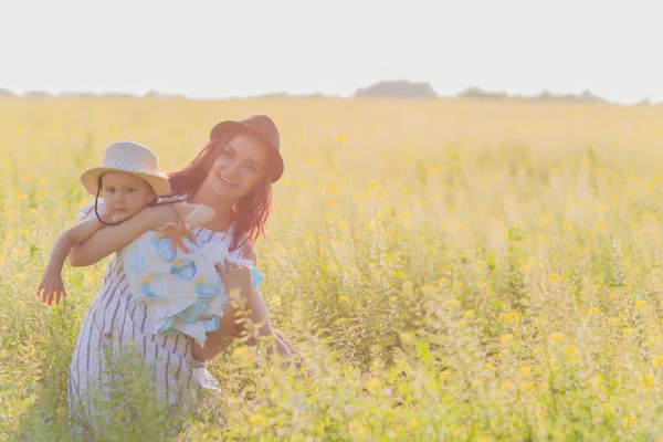 Красива молода мати і її дочка розважаються на пшеничному полі . — стокове фото