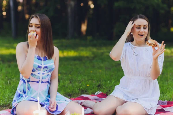 Mujer sonriente teniendo una pausa relajante para almorzar al aire libre, ella está sentada en la hierba y comiendo . — Foto de Stock