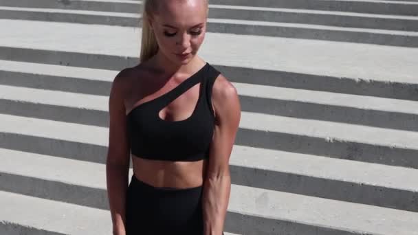 Junge athletische Frau beim Hantelheben, im Rahmen eines frühmorgendlichen Trainings an der Strandpromenade. — Stockvideo