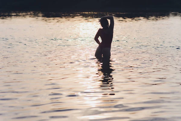 Mulher bonita em maiô vermelho posando perto do rio. Estilo de vida verão. — Fotografia de Stock