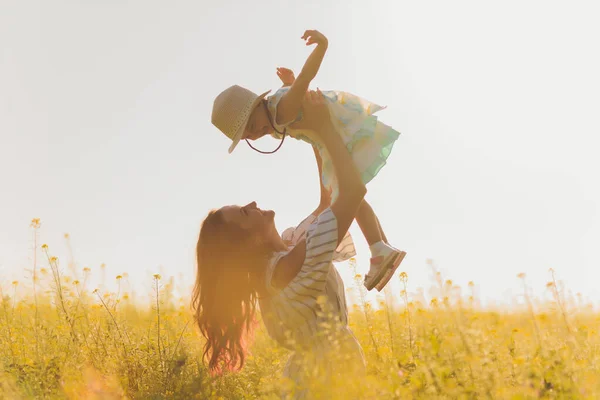 Mooie jonge moeder en haar dochter hebben plezier op het tarweveld. — Stockfoto