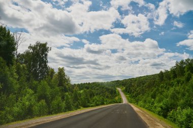 Öndeki yeşil tarlaların doğal görüntüsü ve güneşli bir yaz gününde arka plandaki uçurum ve tepelerin dağları..