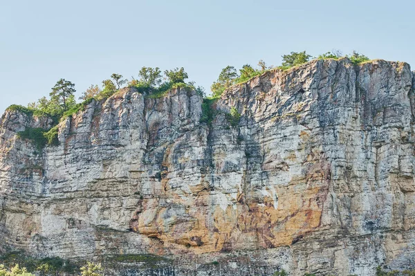 Vista natural de campos verdes em primeiro plano e montanhas de falésias e colinas em segundo plano em um dia ensolarado de verão. — Fotografia de Stock