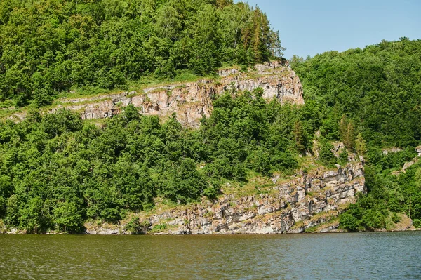 Naturlig utsikt över gröna fält i förgrunden och berg av klippor och kullar i bakgrunden på en solig sommardag. — Stockfoto