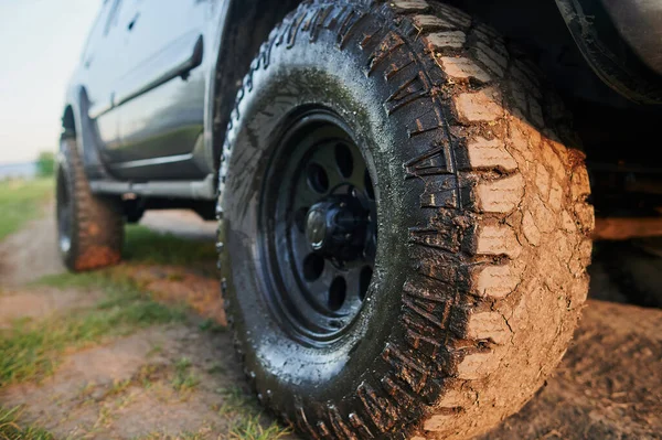 Wheel closeup in a countryside landscape with a muddy road. — Stock Photo, Image