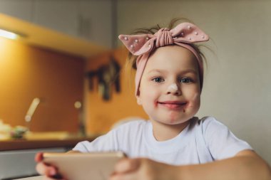 Masada yemek yiyen kız telefonda oynuyor..