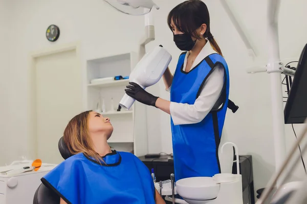 Dentista che lavora con lampada di polimerizzazione dentale in cavità orale. — Foto Stock