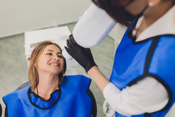 Zahnarzt arbeitet mit Zahnpolymerisationslampe in der Mundhöhle. — Stockfoto