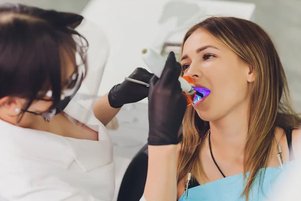 Il dentista rileva i denti cariati del paziente sulla sedia dei dentisti. — Foto Stock