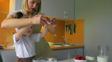Sevimli bir anne ve kızın portresi mutfakta birlikte bir kız hazırlıyor..