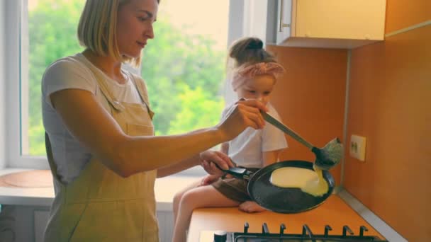 Portrait of an adorable mother and daughter preparing a daughter together in the kitchen. — Stock Video