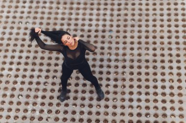 Çekici ve güçlü bir kadın yaz parkında spor öncesi esneme hareketleri yapıyor. Spor konsepti. Sağlıklı yaşam tarzı.