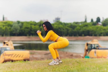 Yaz günü tayt ve yeleklerle spor yapan çekici bir kız..