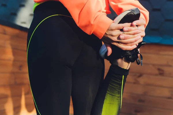 Junge Fitness-Läuferin streckt Beine vor dem Lauf am Kai, Rückansicht, leerer Raum. — Stockfoto
