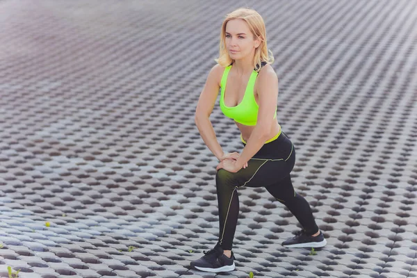 Fiatal nő csinál néhány bemelegítő gyakorlatot futás előtt. — Stock Fotó