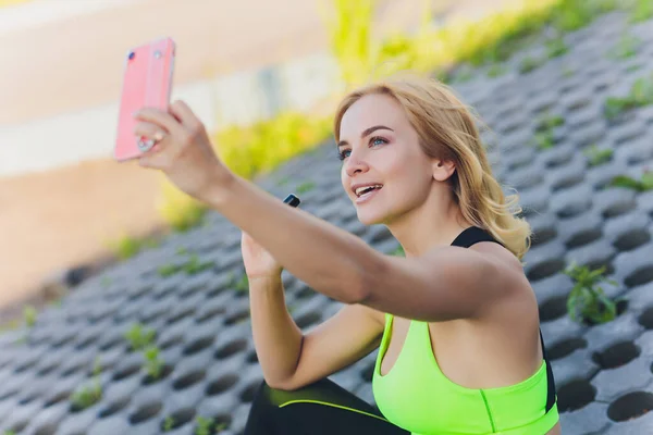 Hübsche junge Yogalehrerin, die einen Online-Kurs leitet. Junge Frau praktiziert Yoga mit ihrem Handy. — Stockfoto