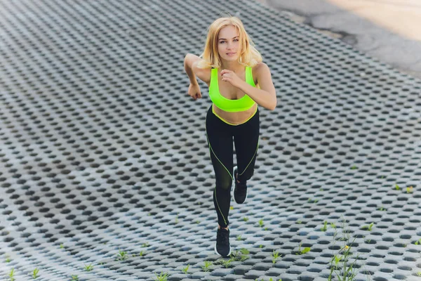 Вид зверху на жінку, що біжить по міському асфальту. Жіночий бігун тренування на відкритому повітрі . — стокове фото