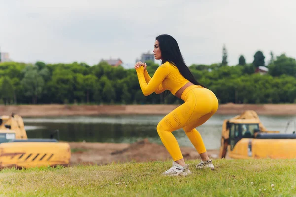 Chica atractiva haciendo deportes en un día de verano en mallas y chalecos con el pelo atado hacia atrás. — Foto de Stock