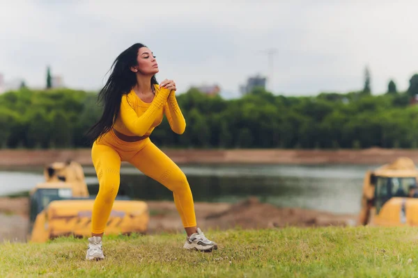 Menina atraente fazendo esportes em um dia de verão em collants e coletes com cabelo amarrado de volta . — Fotografia de Stock