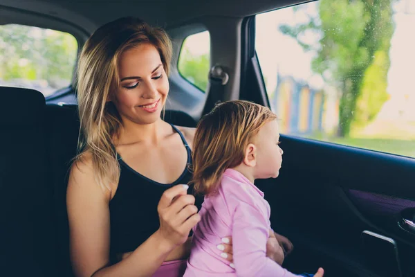 Petit bébé tout-petit fille regarde par la fenêtre de la voiture avec sa mère. — Photo