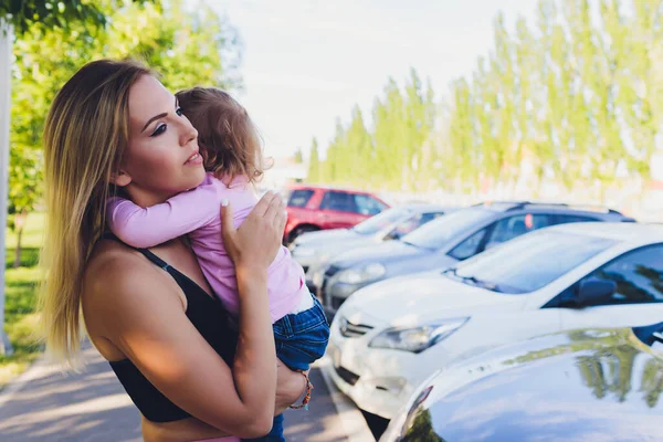 Mooie vrouw houdt een jaar oude baby in haar armen in het park. Moederschap en familie. Zorg en ontwikkeling van het kind. — Stockfoto