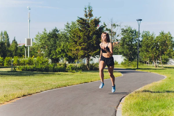 Jovem mulher correndo no parque no verão . — Fotografia de Stock