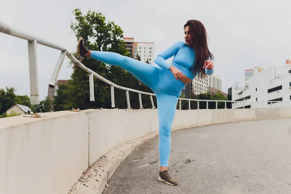 A young woman is preparing for outdoor sports on the modern promenade near her apartment complex. — Stock Photo, Image