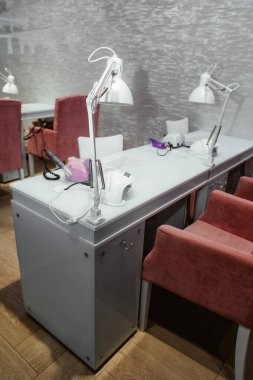 Manikür ve pedikür salonu modern, ojeli beyaz arka planda sıra sıra..