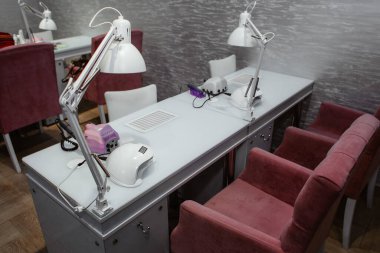 Manikür ve pedikür salonu modern, ojeli beyaz arka planda sıra sıra..