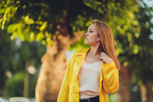 Projevuje módní tendence. Tmavovlasá atraktivní žena v jasně žlutém načechraném plášti. — Stock fotografie