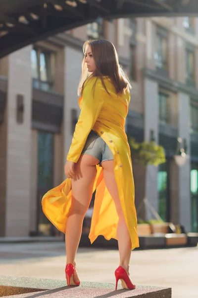 Mostrando tendências de moda. Mulher atraente de cabelos escuros posturando no manto fofo amarelo brilhante. — Fotografia de Stock