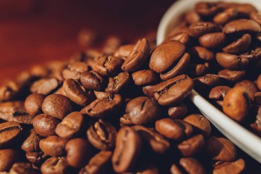 Arka planda kahve çekirdeği olan bir fincan kapuçino..