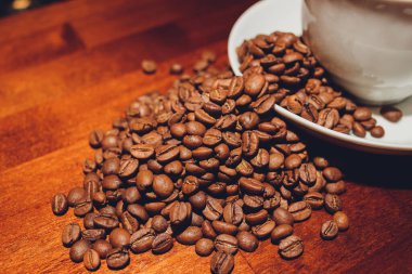 Arka planda kahve çekirdeği olan bir fincan kapuçino..