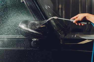 Modern lüks arabanın yan aynasındaki boya korumalı film kurulumunu kapatın. PPF, boyalı arabalara uygulanan poliüretan filmdir. Boyayı taş parçalarından, böcek lekelerinden ve aşınmadan korumak için.