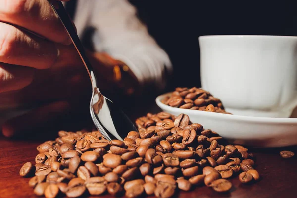 세라믹 컵에 들어 있는 다크 커피 콩. 상징적 인 이미지입니다. 나무로 된 엄청난 배경. 닫아. 복사 공간. — 스톡 사진