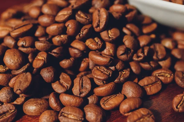 Chicchi di caffè scuro in una tazza di ceramica. Immagine simbolica. Fondo in legno rustico. Chiudete. Copia spazio. — Foto Stock