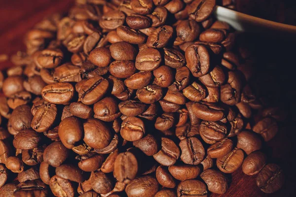 Chicchi di caffè scuro in una tazza di ceramica. Immagine simbolica. Fondo in legno rustico. Chiudete. Copia spazio. — Foto Stock