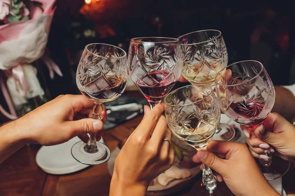 Primer plano del grupo de personas tintineando copas con vino o champán en frente de fondo bokeh. personas mayores manos. —  Fotos de Stock