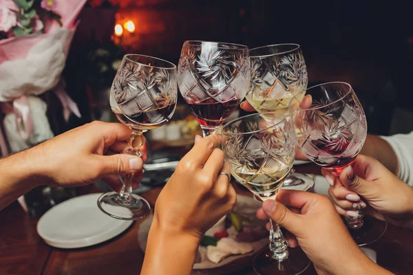 Primer plano del grupo de personas tintineando copas con vino o champán en frente de fondo bokeh. personas mayores manos. —  Fotos de Stock