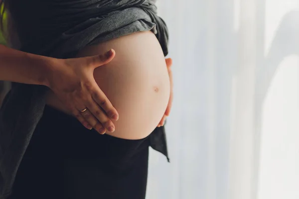 Imagem da mulher grávida tocando sua barriga com as mãos. — Fotografia de Stock