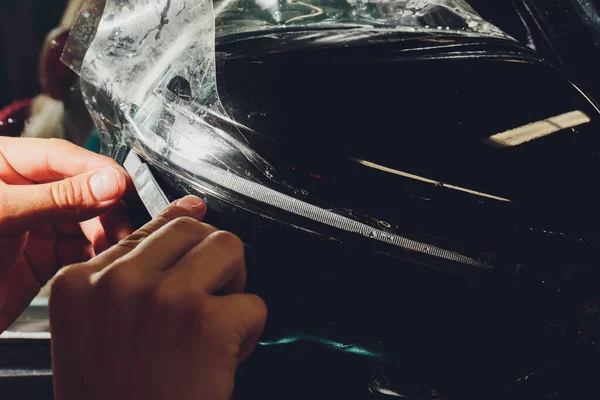 Close-up van de lak bescherming film installatie aan de zijkant spiegel van de moderne luxe auto. PPF is polyurethaan film toegepast op geschilderd van auto om de verf te beschermen tegen stenen chips, bug splatter, en slijtage — Stockfoto