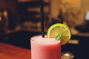 Lokantadaki barda kokteyl. Limonla süslenmiş kokteyl, mesaj için yer. Menü için fotoğraf.