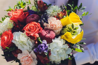 Bir sürü farklı çiçekli bir çiçek buketi.