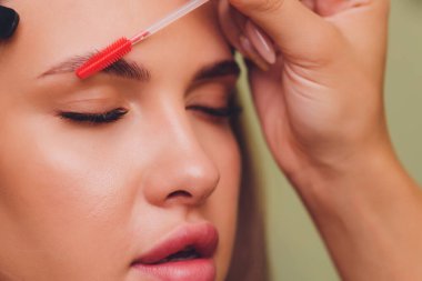 Güzellik salonunda profesyonel kaş düzeltme prosedürü olan genç bir kadın..