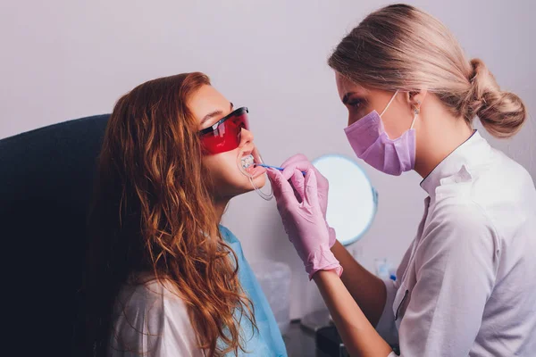 클리닉에서 치아를 하얗게 하기 위해 치과를 방문하는 한 여성 환자의 확대 사진, 치아를 희게 하는 절차. — 스톡 사진