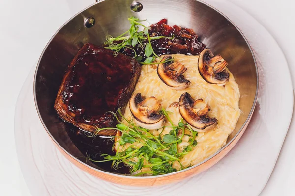 Een gegrilde rib steak met gebakken champignons en aardappelpuree doordrenkt met hartige kruiden. — Stockfoto