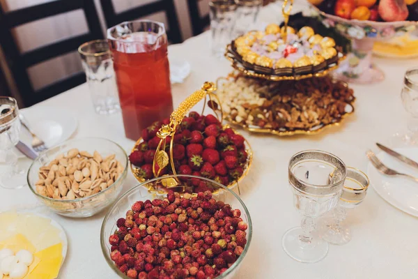Čerstvé jahody v hliněném talíři na dřevěném stole, výhled shora. — Stock fotografie