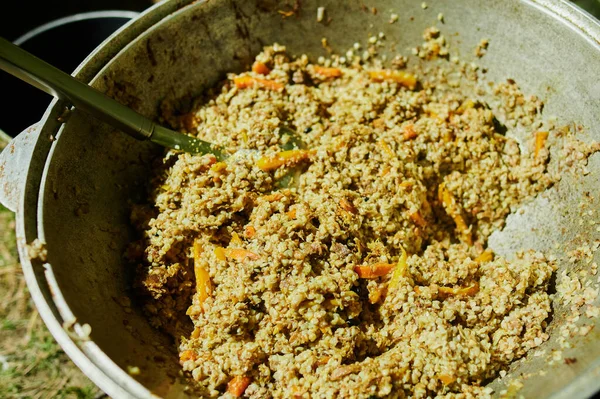 La cocción del sabroso pilau con la carne en la caldera grande afuera. Comida callejera. Primer plano. —  Fotos de Stock