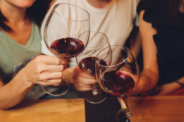 Close-up tiro de grupo de pessoas que clica copos com vinho ou champanhe na frente de fundo bokeh. pessoas idosas mãos. — Fotografia de Stock